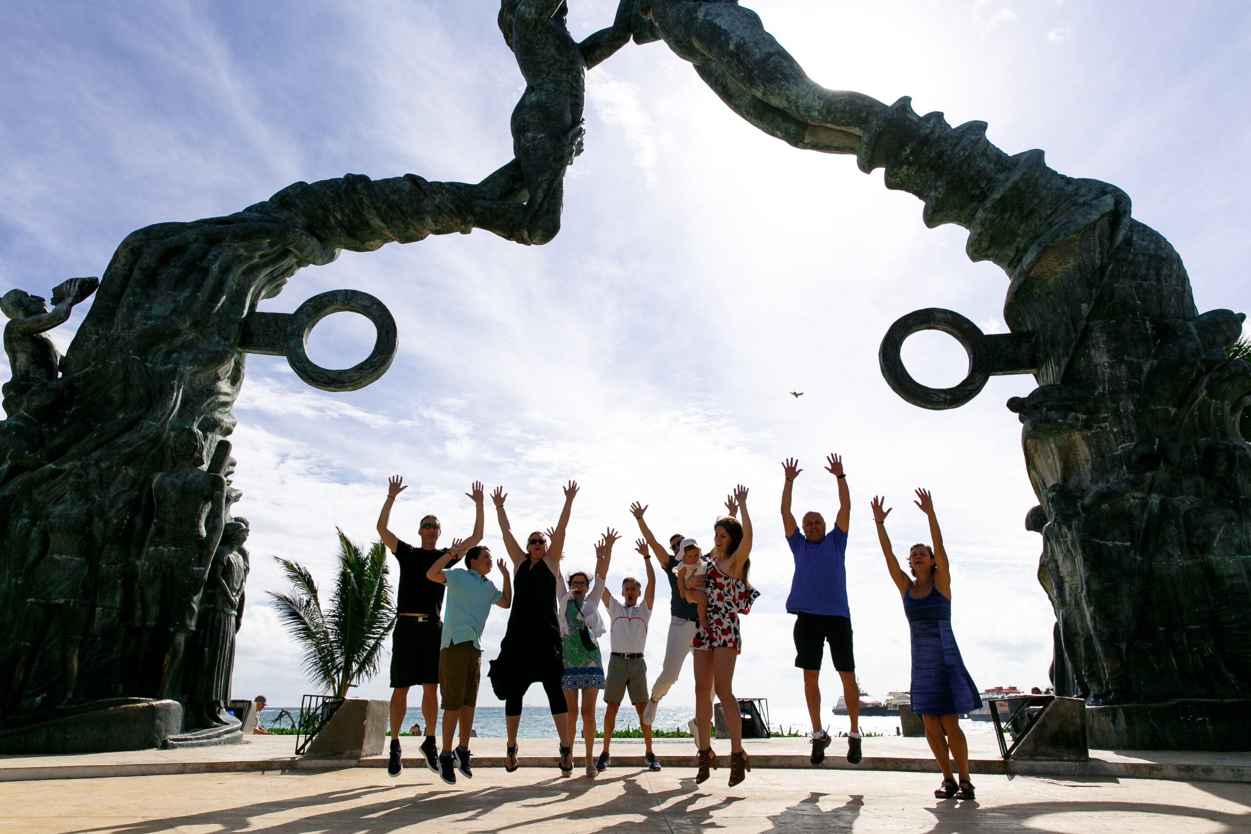 Megan + Hany's family jump for joy under Playa del Carmen arch