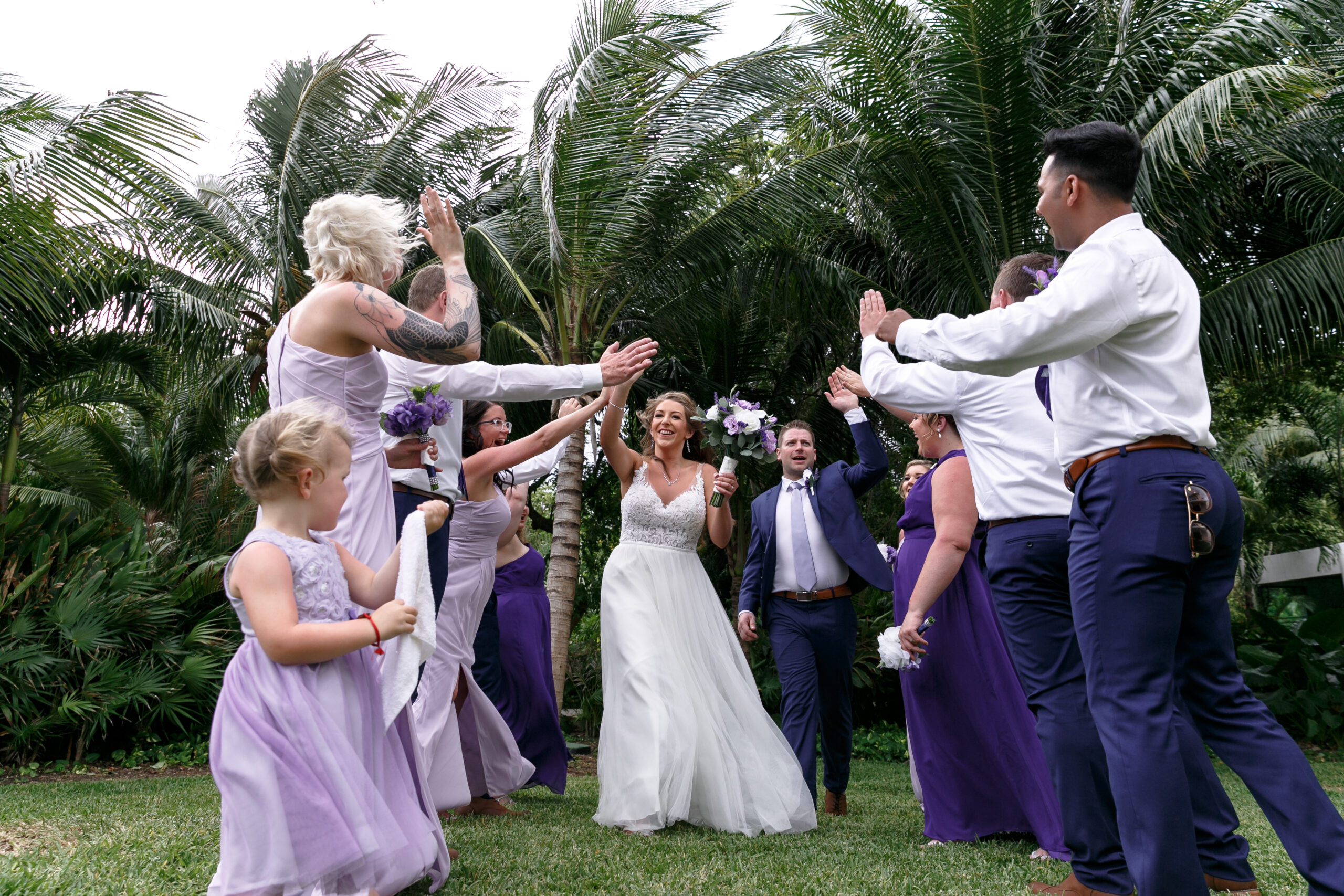 Bride + Groom walk gauntlet of high fives from wedding party