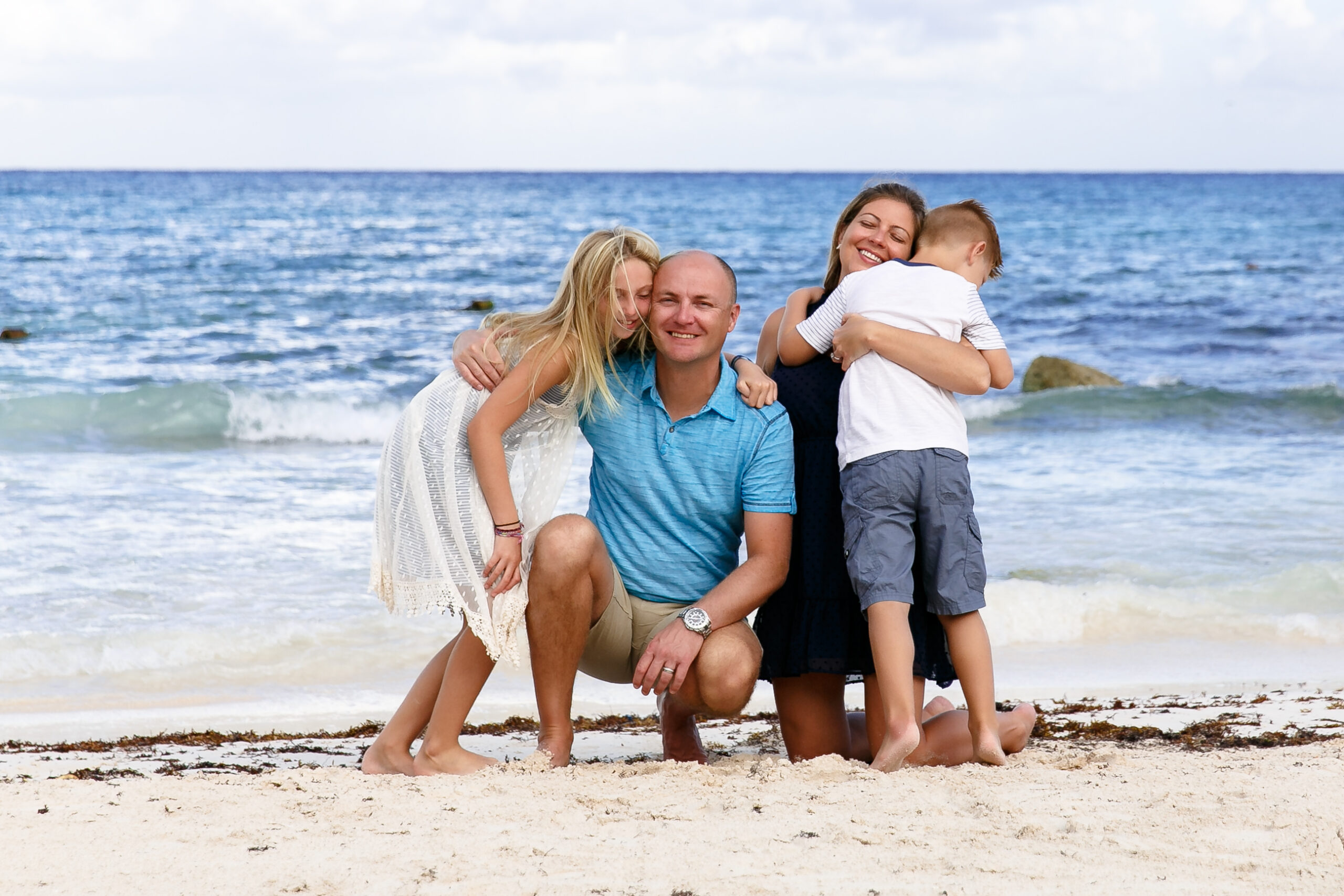 Family hugs on beautiful Barcelo beach