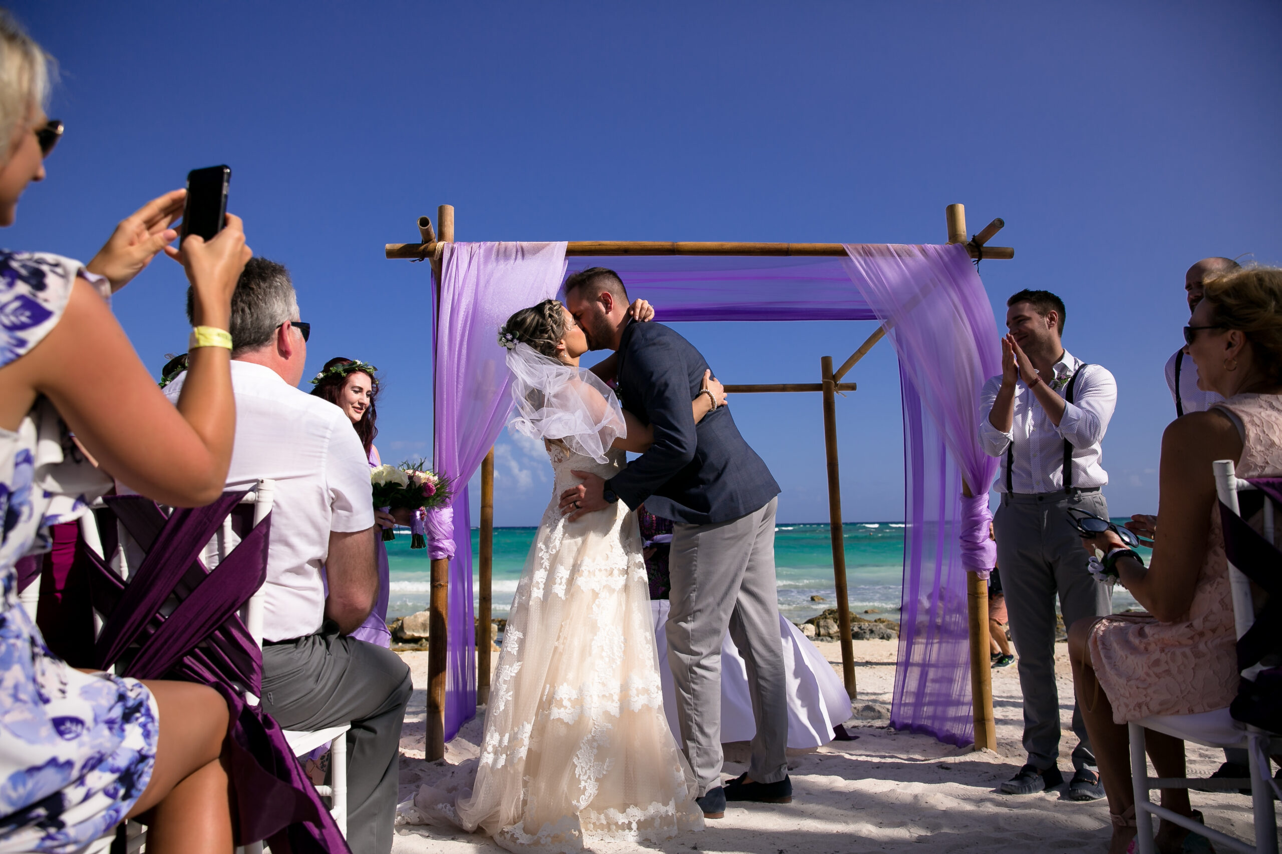 Newlyweds first kiss at Barcelo Maya Colonial beach wedding