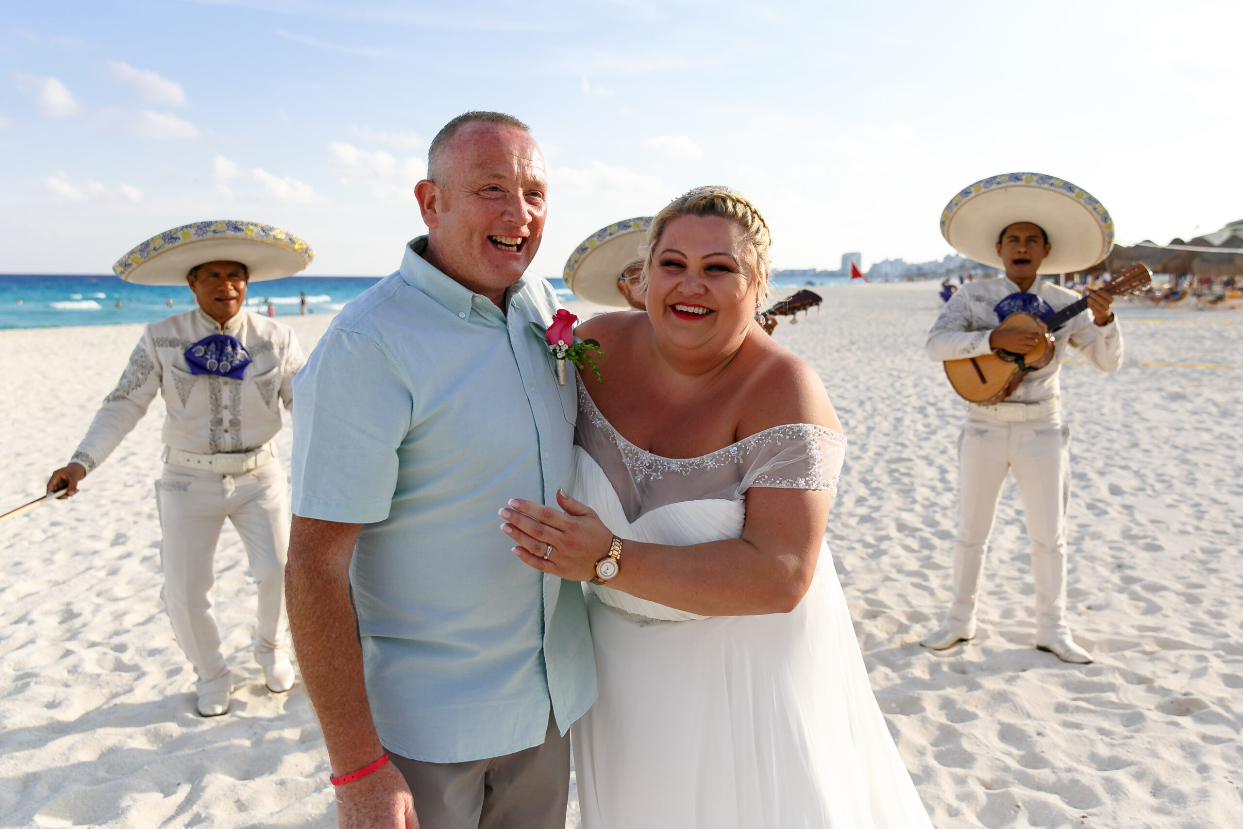 Newlyweds embrace in front of their mariachi band