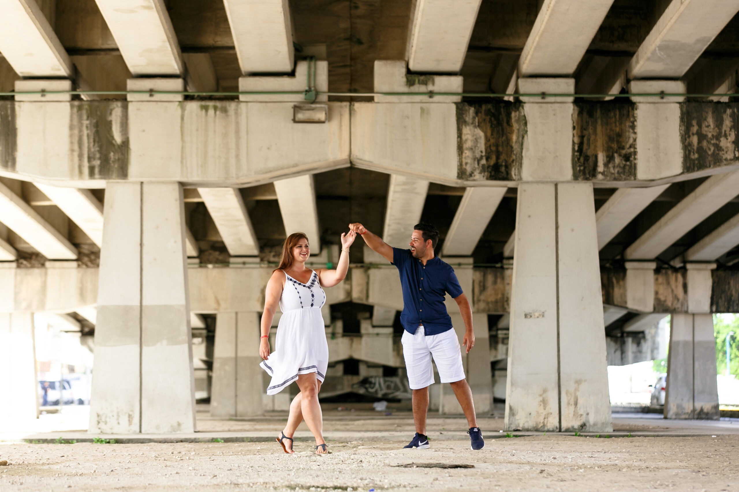 Happy couple dances under Playa del Carmen bridge