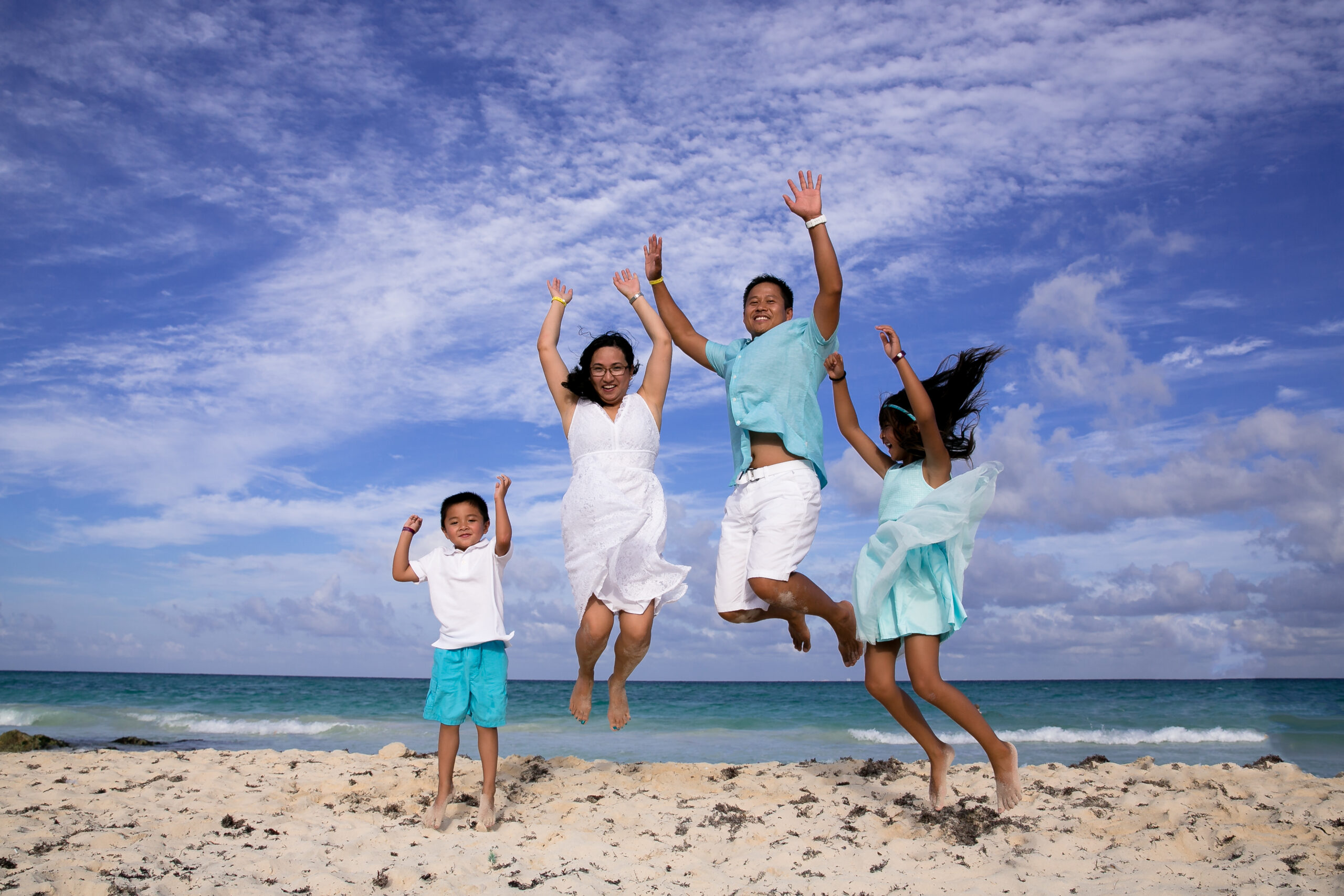 Family jumps for joy on Playa del Carmen beach