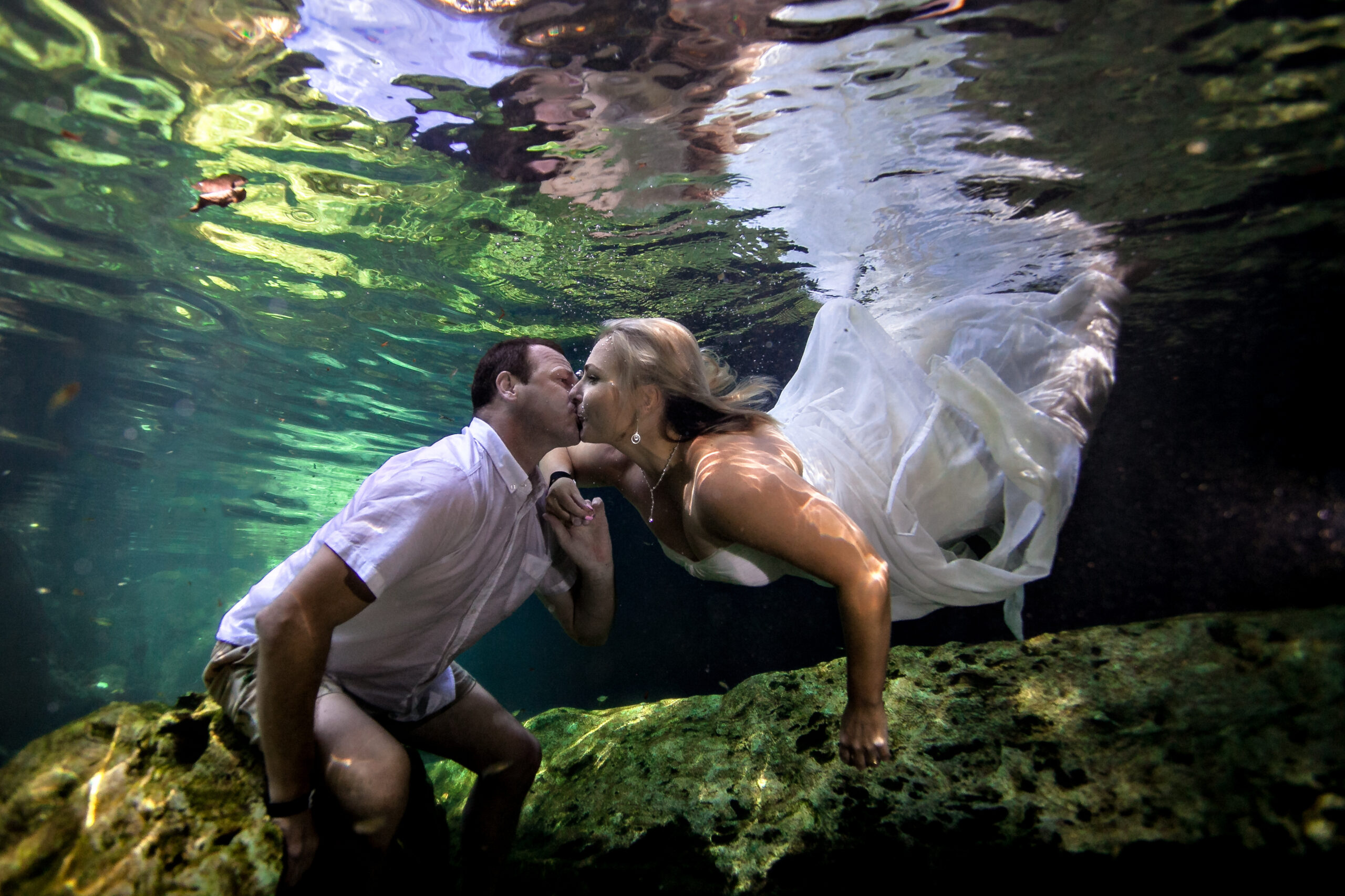 Anniversary couple kiss underwater in Playa del Carmen cenote