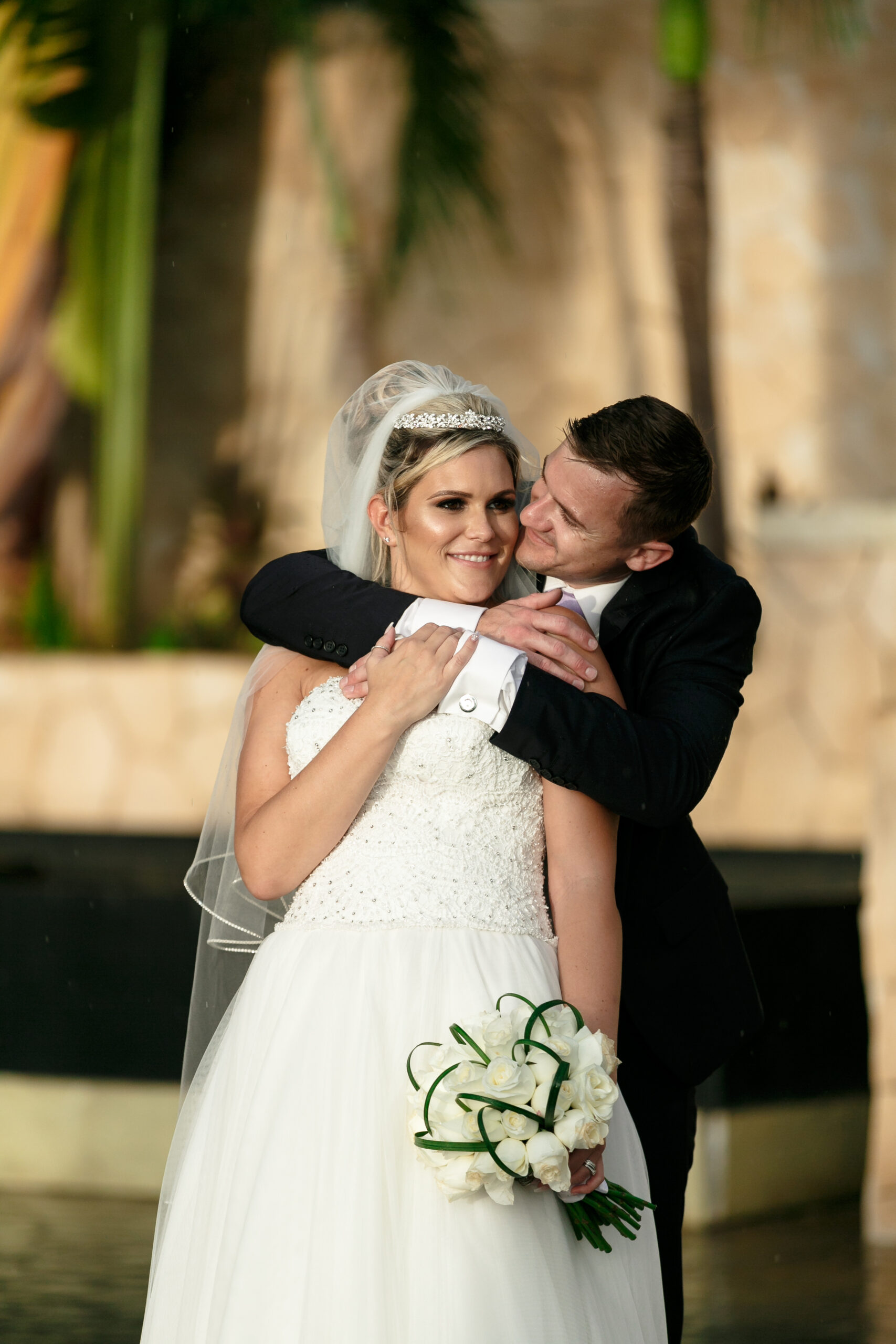 Groom wraps his arm around his newlywed bride