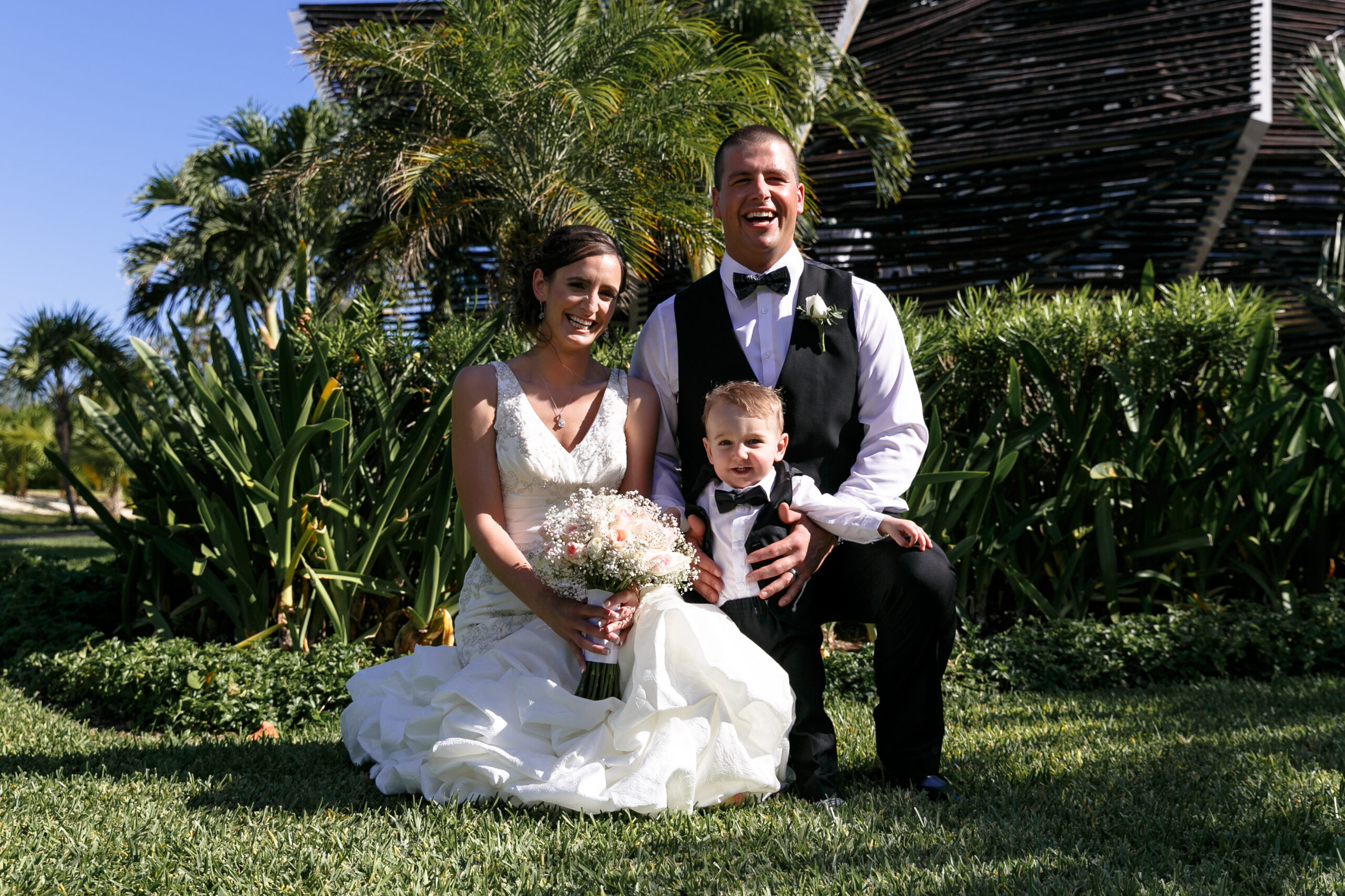 Newly married parents pose with infant son in Royalton gardens