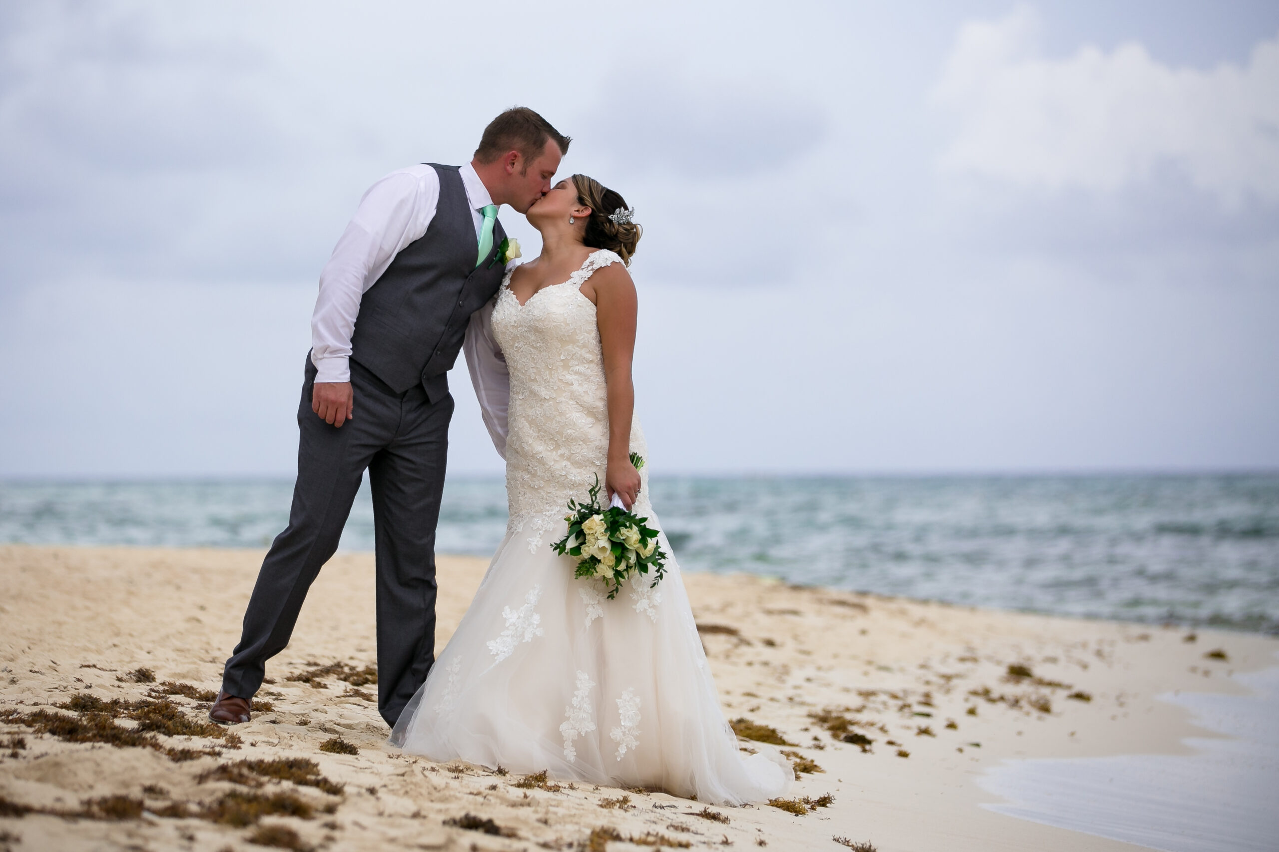 Newlyweds kiss on Sandos Caracol beach