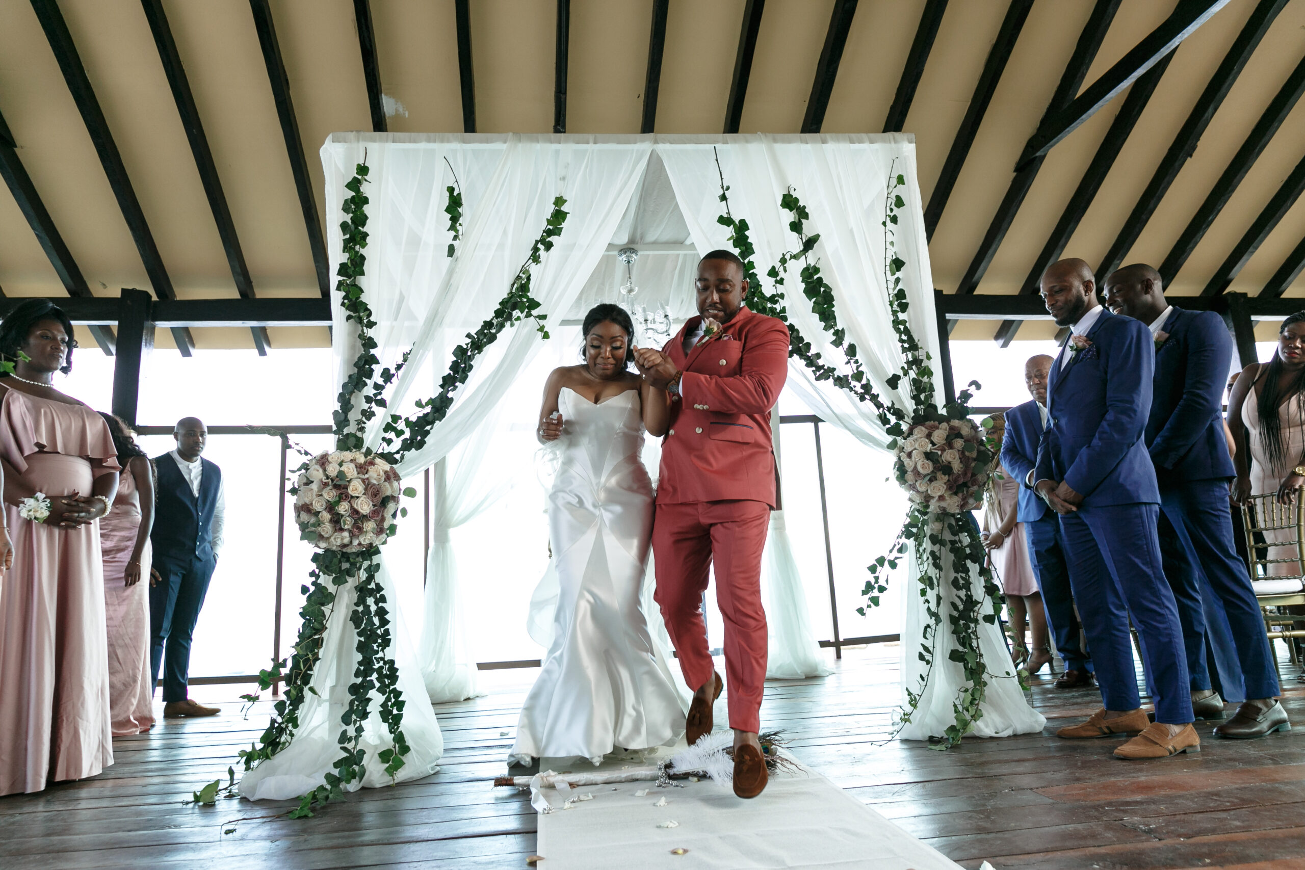 Bride + Groom jump over the broom as symbol of "tying the knot"