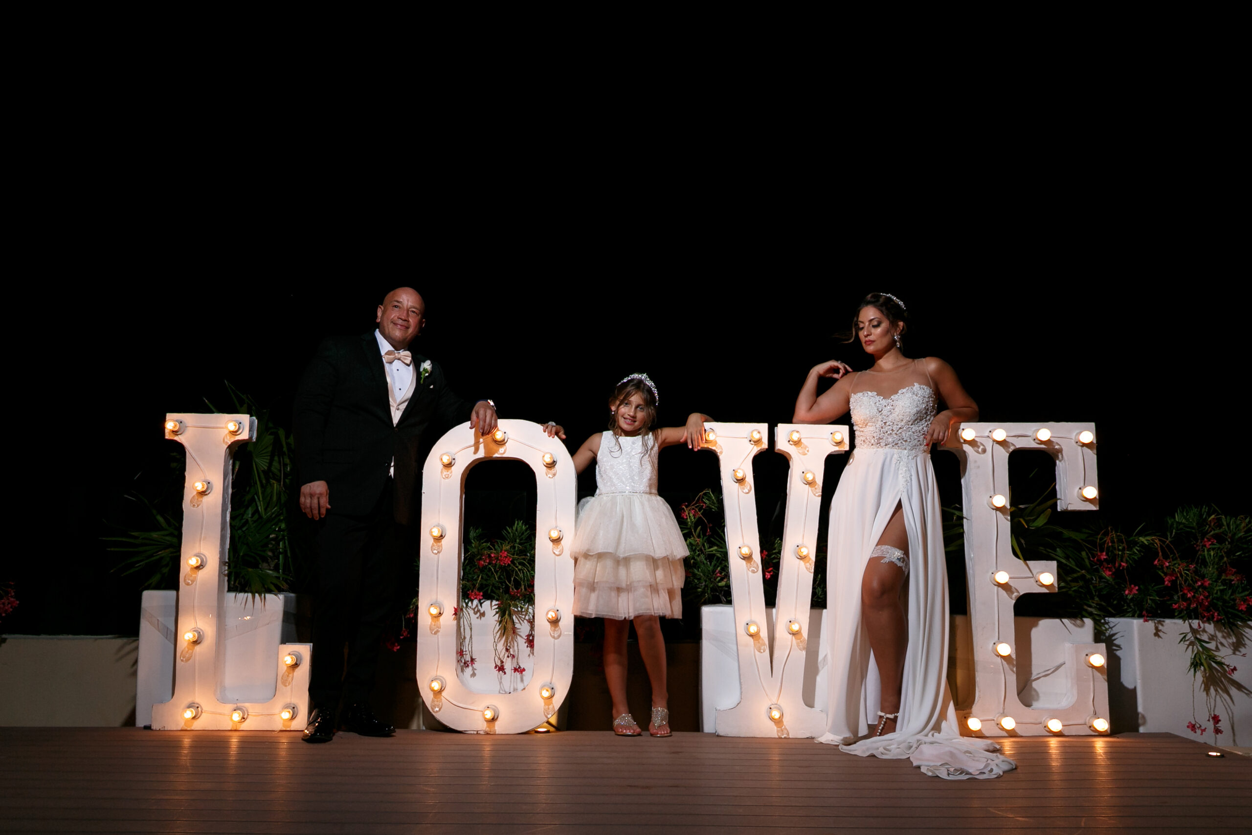 Newlyweds pose with their daughter by the LOVE sign