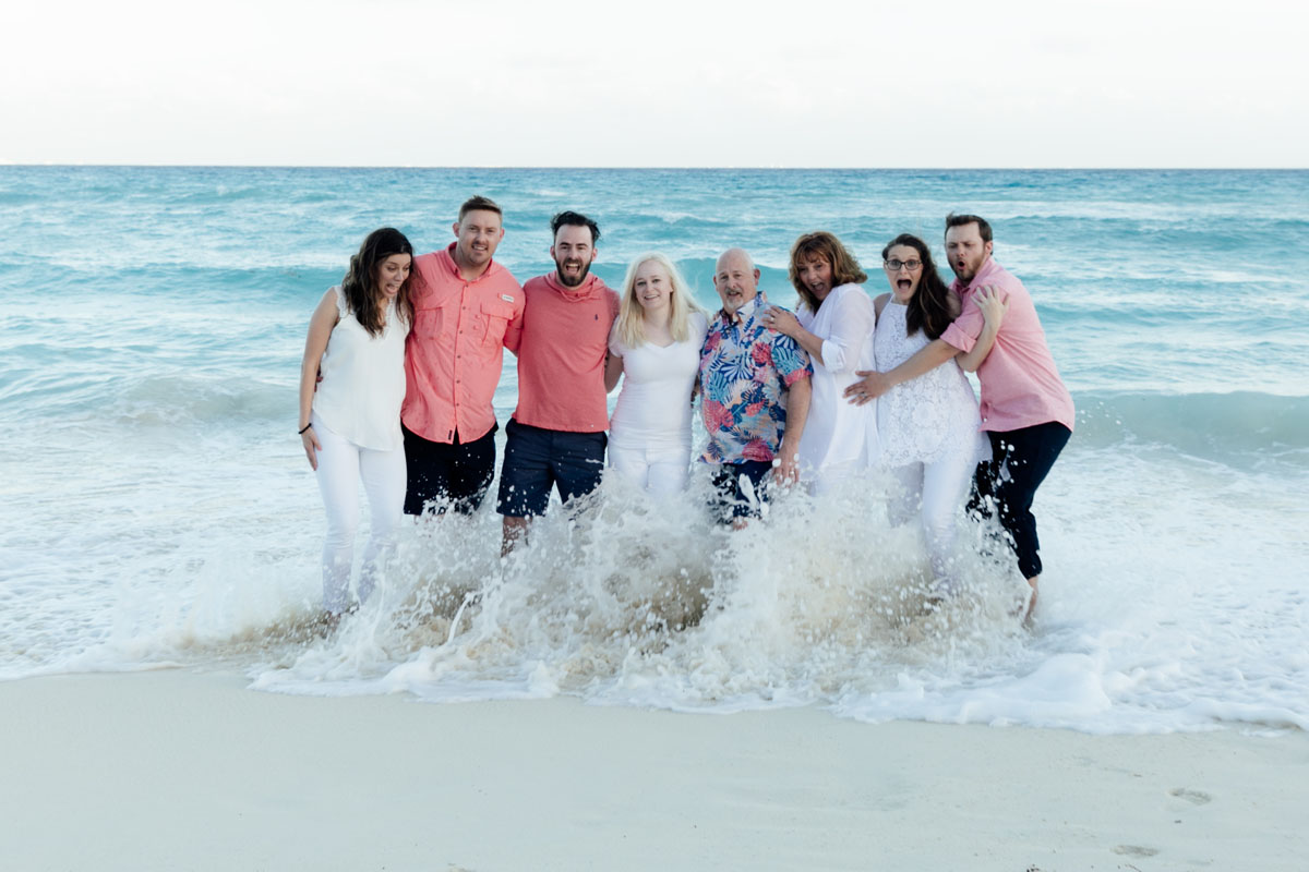 Family standing in ocean surf wave