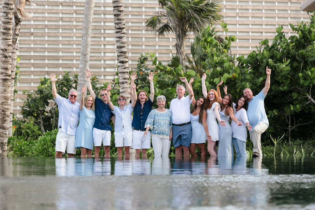 Family generations cheer behind infinity edge pool