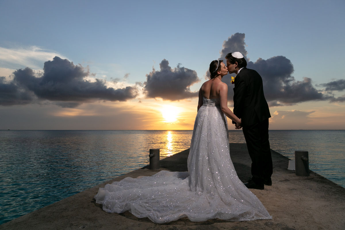 Westin Cozumel newlyweds kiss on pier in golden sunset glow