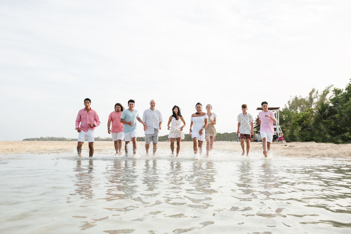 Family runs into the ocean, splashing