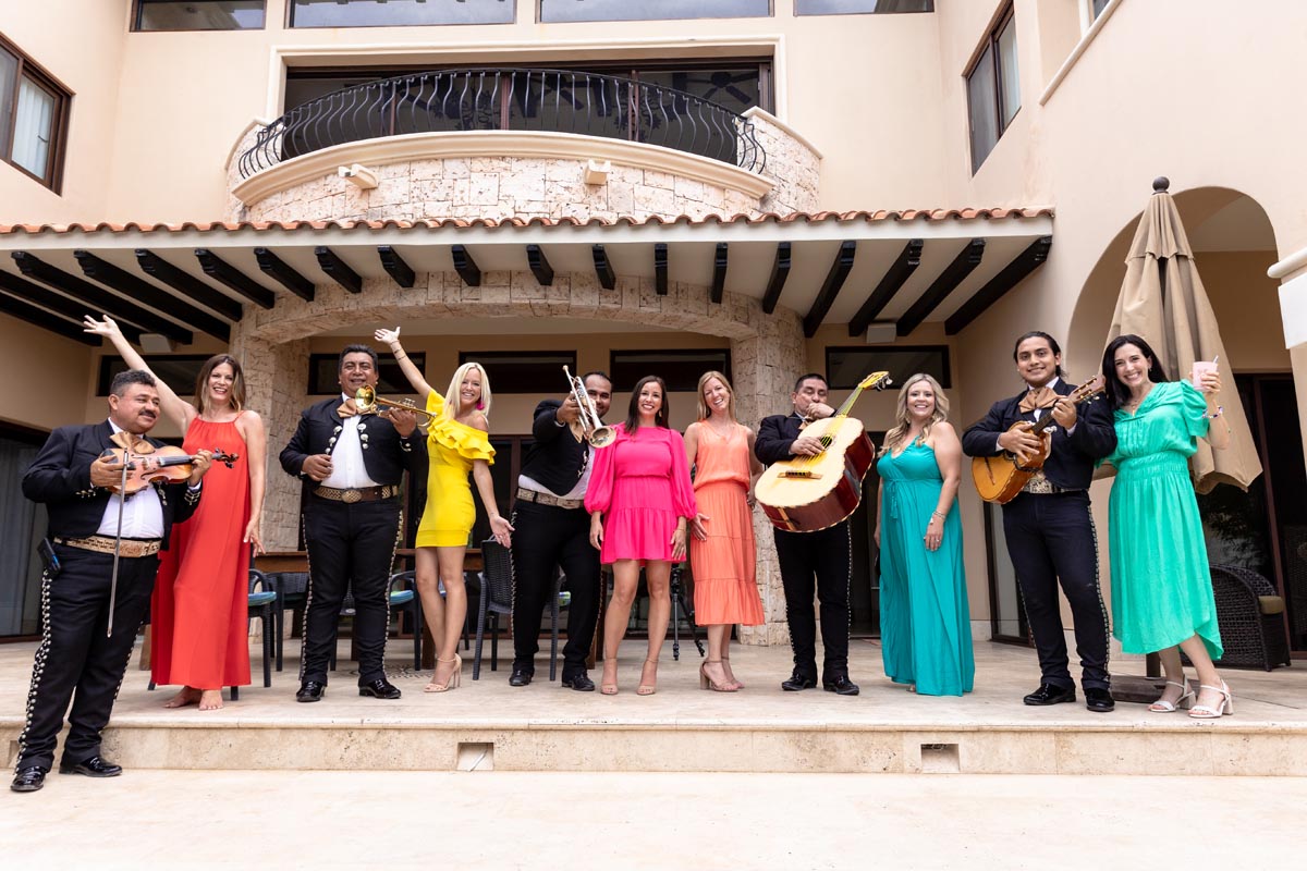 Group of friends pose with mariachis on the steps of Vidorra Villa