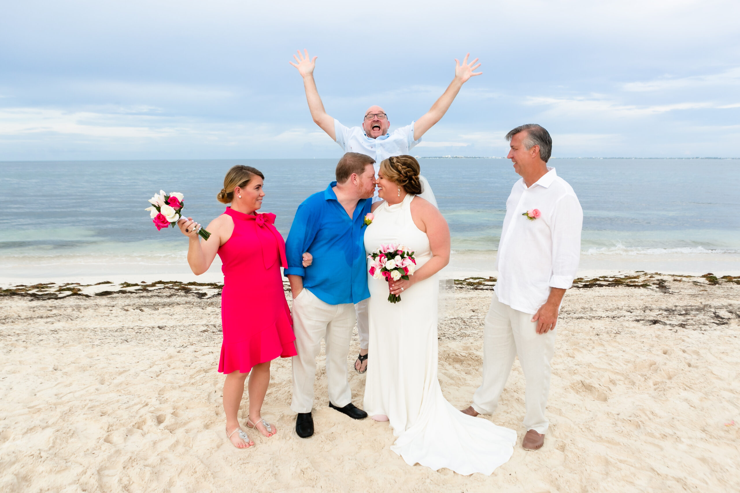 Friend photobombs newlyweds kiss on the beach with their attendants