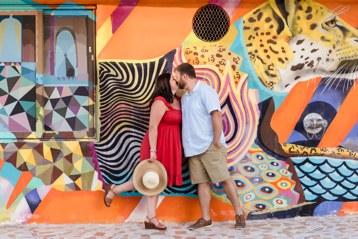 Romantic couple kiss in front of graffiti wall