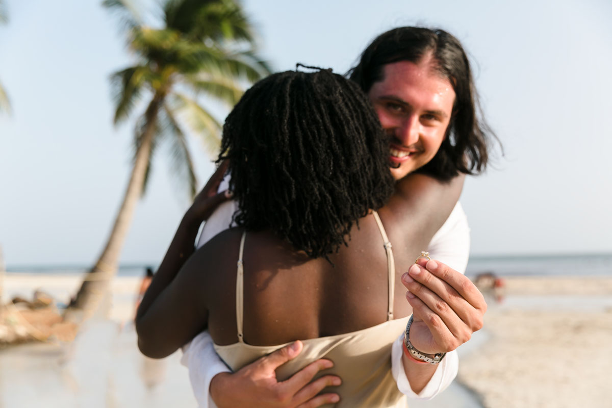 Newly engaged couple hug with Finace holding up her ring