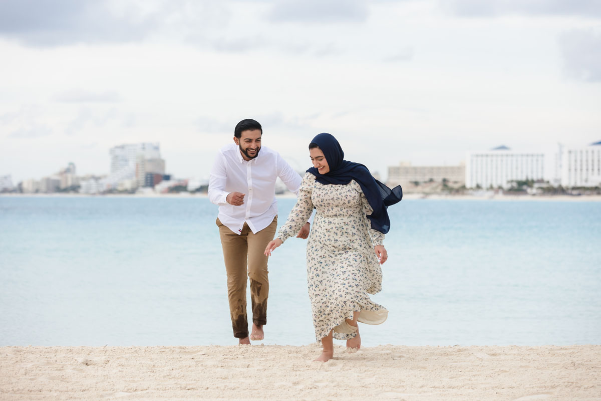 Happy couple runs on the beach