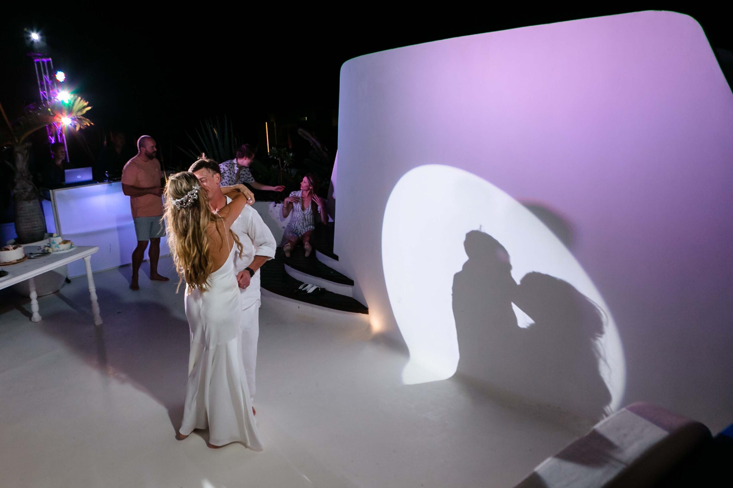 Newlyweds dance beside their shadow on the wall