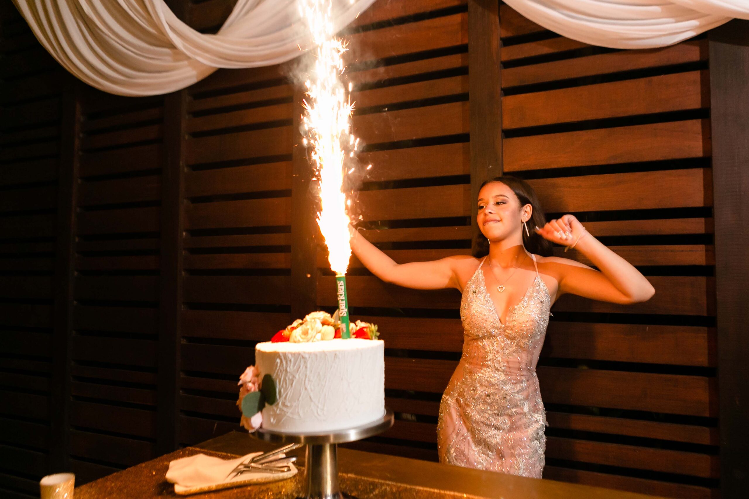 Quinceanera gril dances behind her cake spouting fireworks