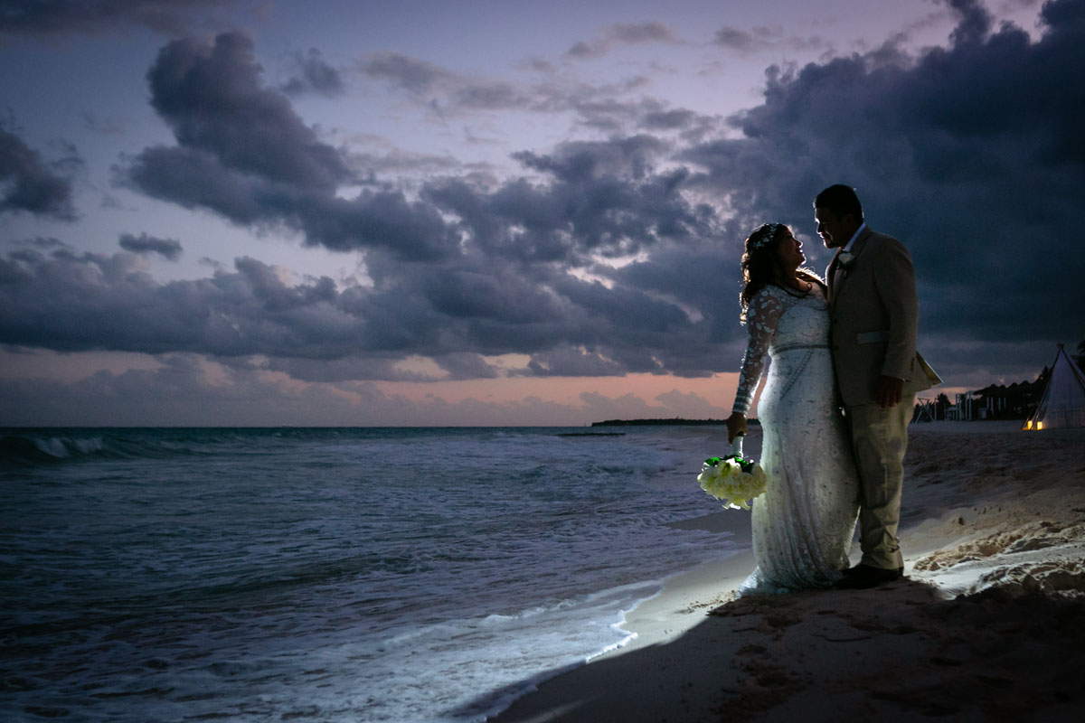 Vows Renewal couple embrace on the beach under dramatic skies