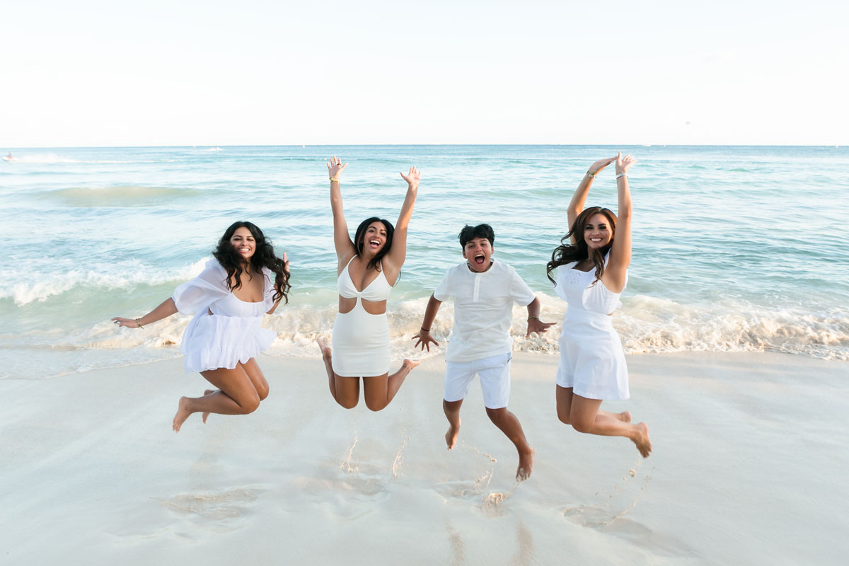 Family jumps for joy on Playa del Carmen's beach