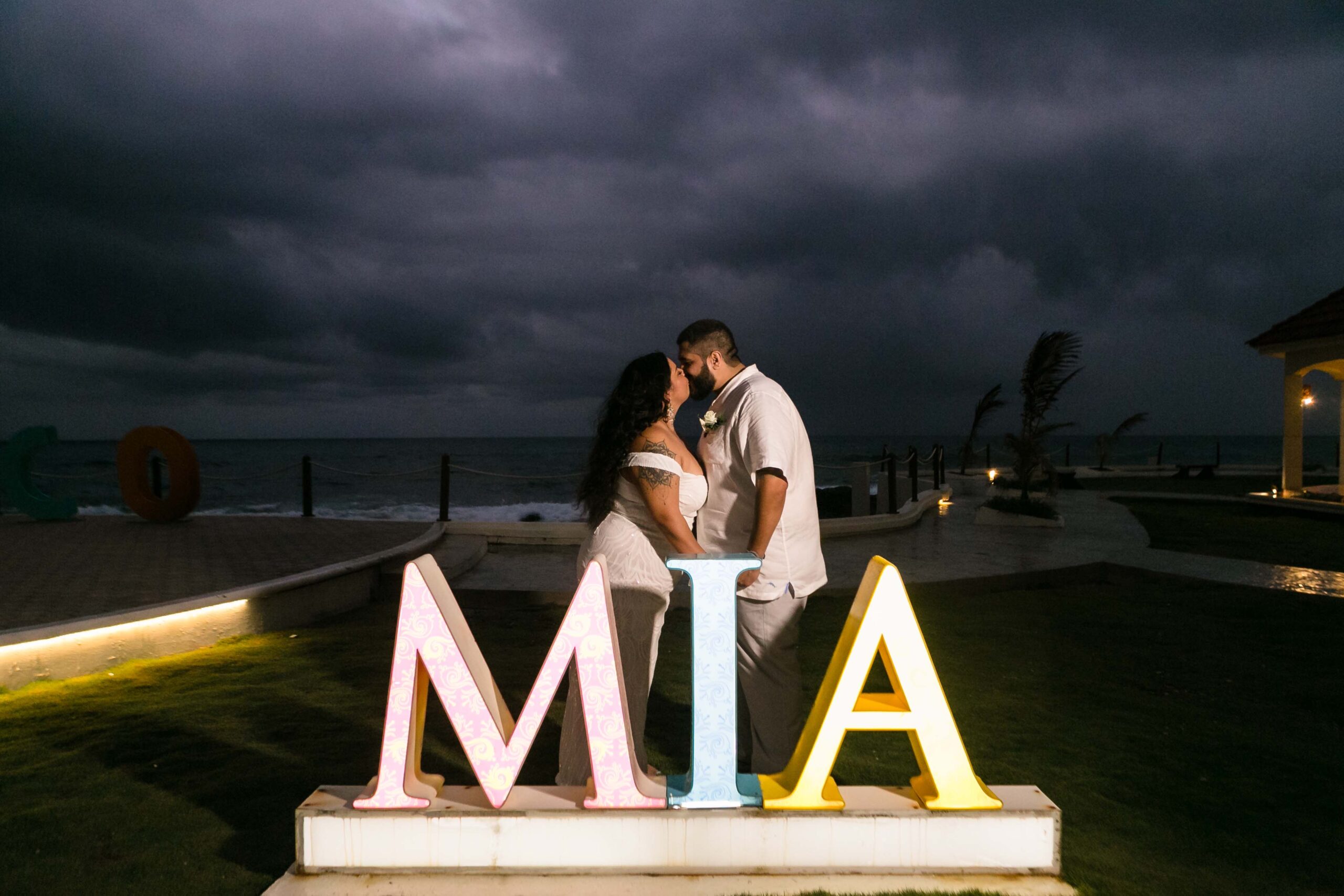 Newlyweds kiss behind Mia sign