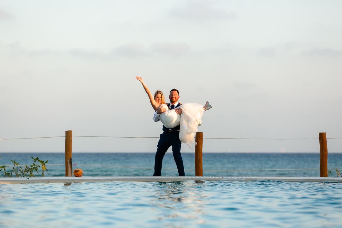 Newlywed groom holds his cheering bride