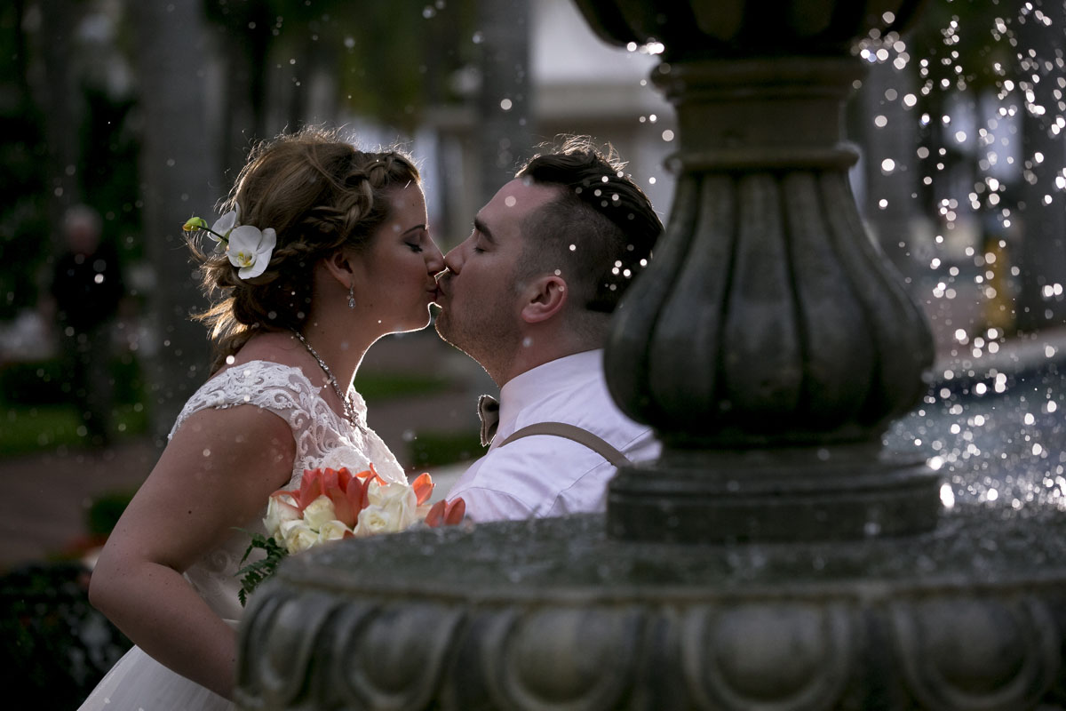 Newlyweds kiss under fountain trickling water