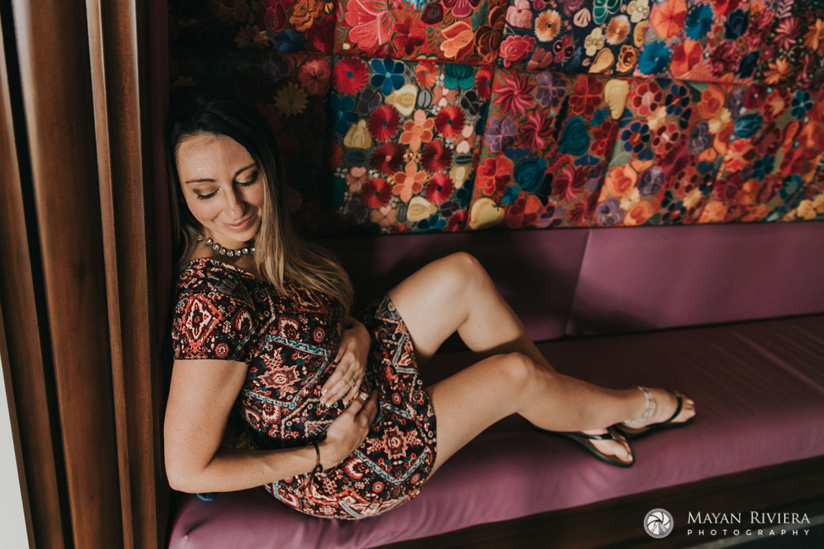 ExpectantMomLoungesOnCouchCraddlingBabyBump