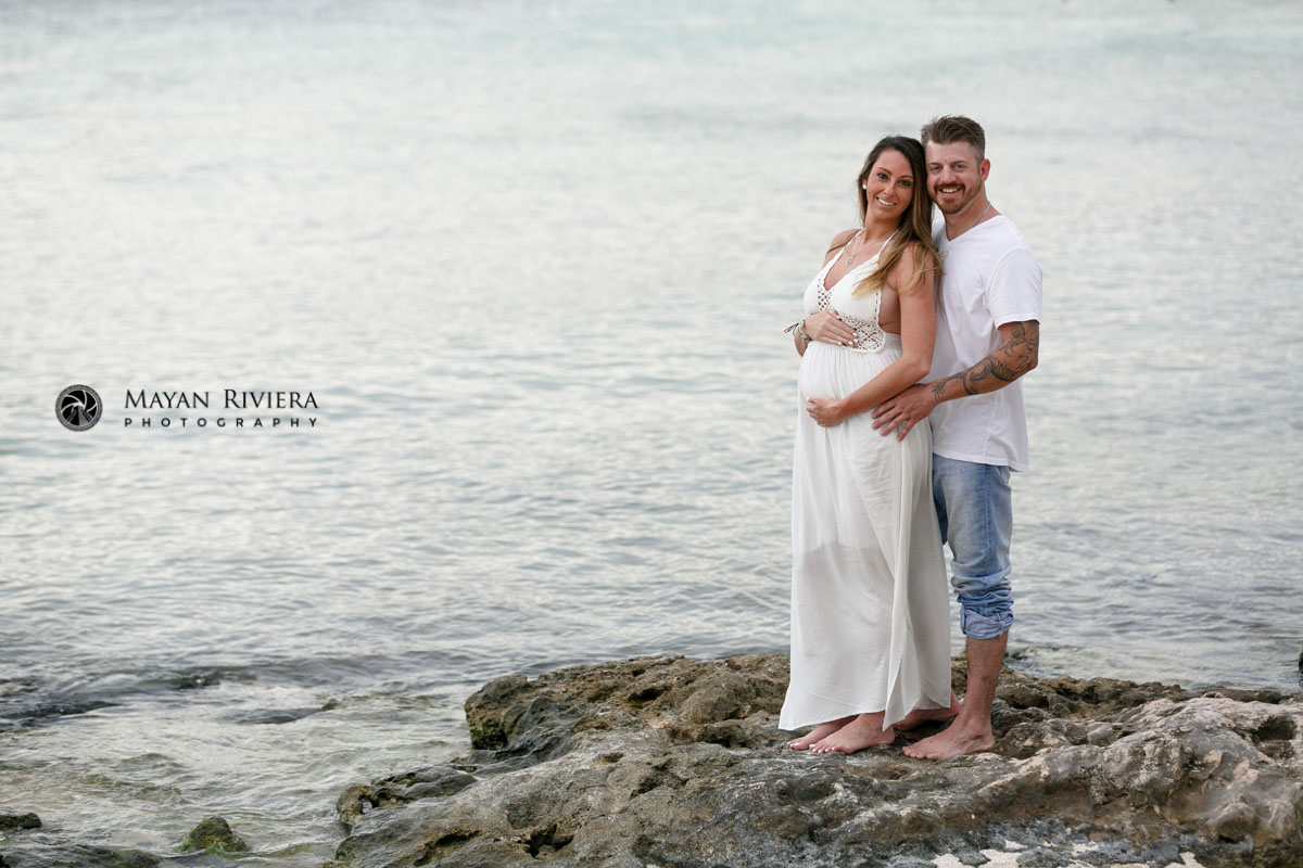 ExpectantMomCradlesBabyBumpStandingOnRocks