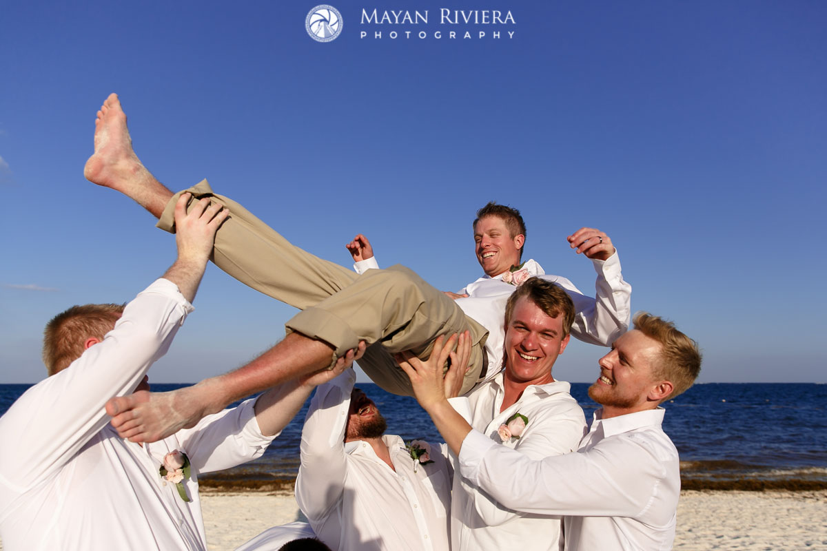 WeddingPartyHoistsGroomOnBeach
