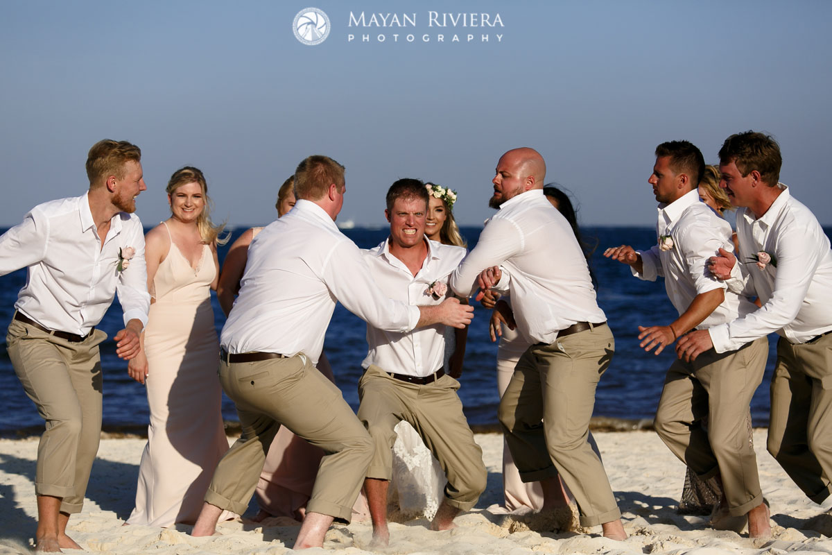 WeddingPartyHoistsGroomOnBeach