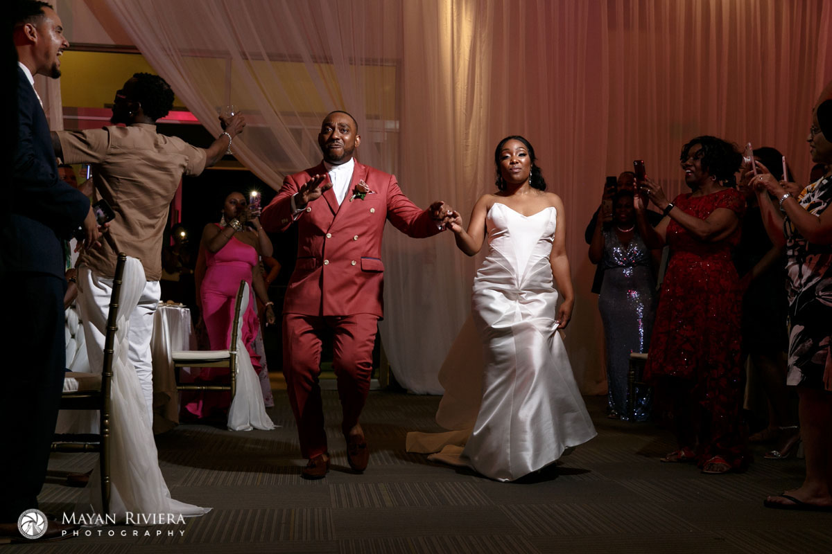 NewlywedsWalkingIntoReceptionBallroom