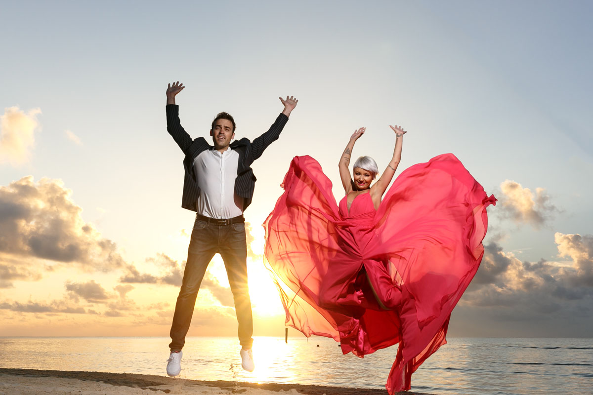 CouplesJumpingShilouetteSunriseShiningThruSkirt