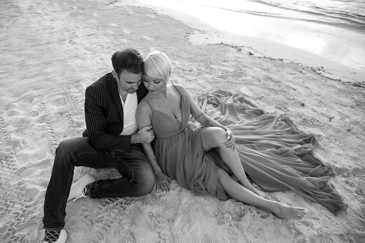 CoupleReclineOnBeachAtSunrise