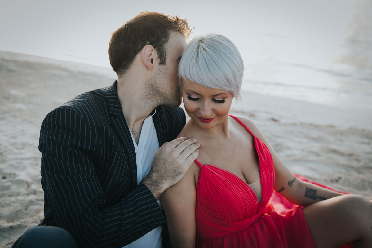 CoupleSnuggleOnBeachAtSunrise