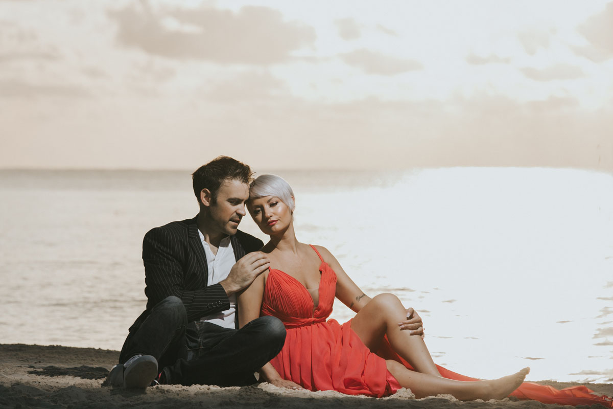 CoupleReclineOnBeachAtSunrise