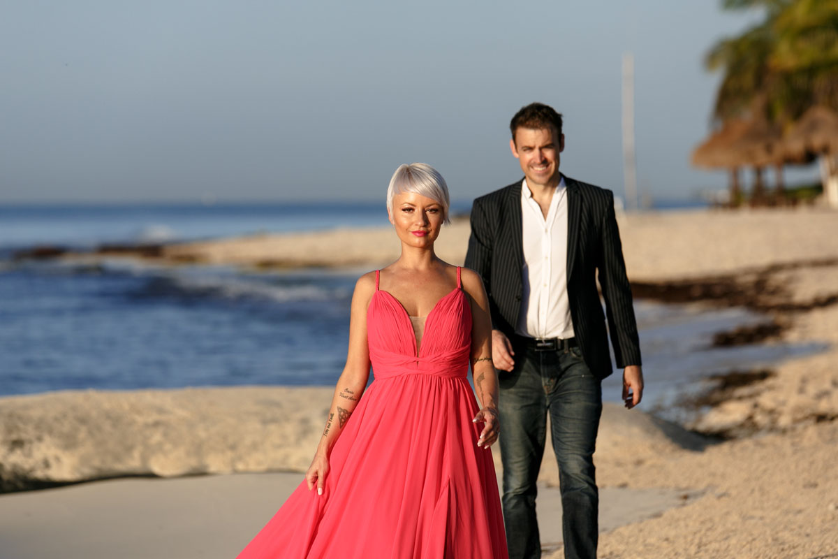 CoupleWalkingOnBeachAtSunrise