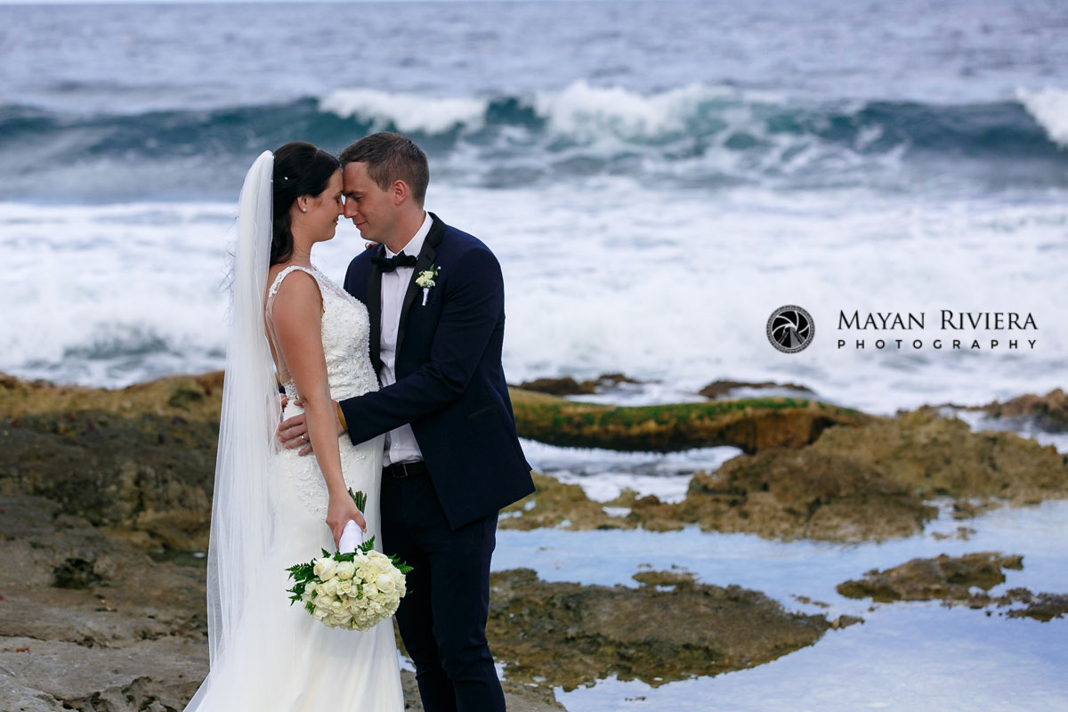 EmotionalNewlywedsTouchForeheadsOnBeach