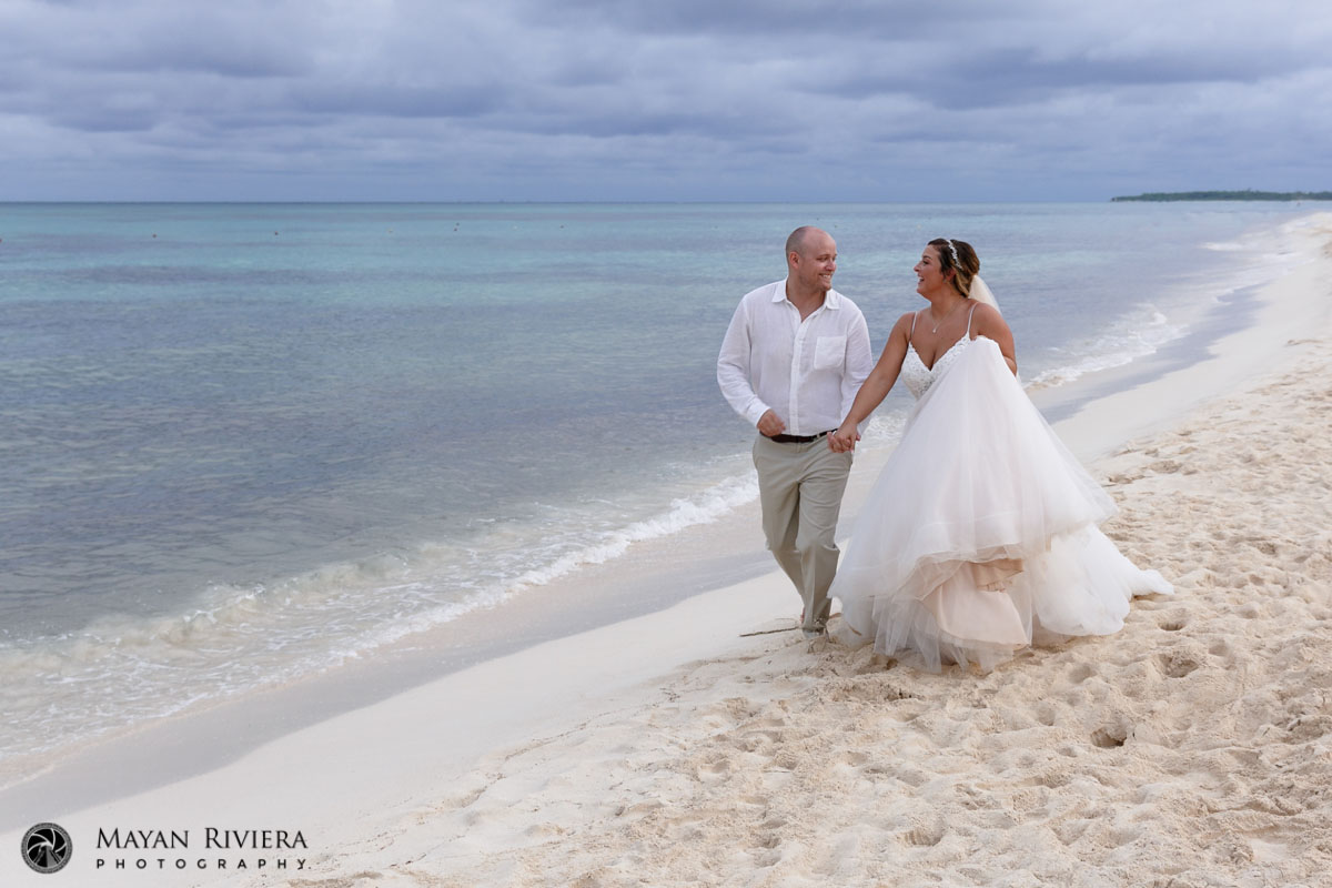 NewlywedsGazeAtEachOtherOnBeachStroll
