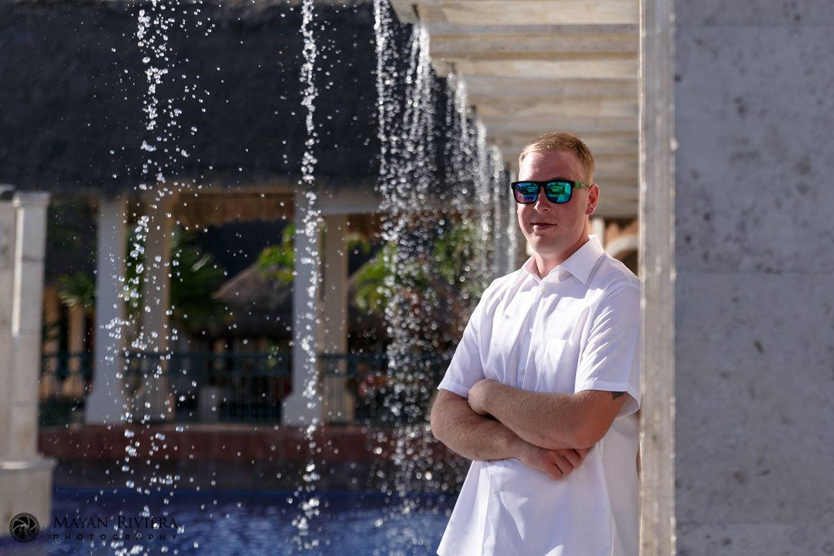 GroomLeaningOnWallByWaterfall