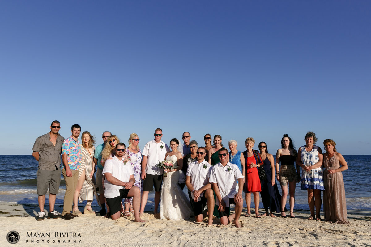 NewlywedsPoseWithGuestsOnBeach