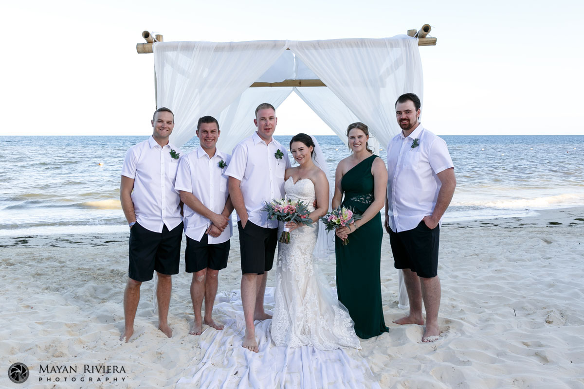 NewlywedsPoseWithWeddingPartyOnBeach