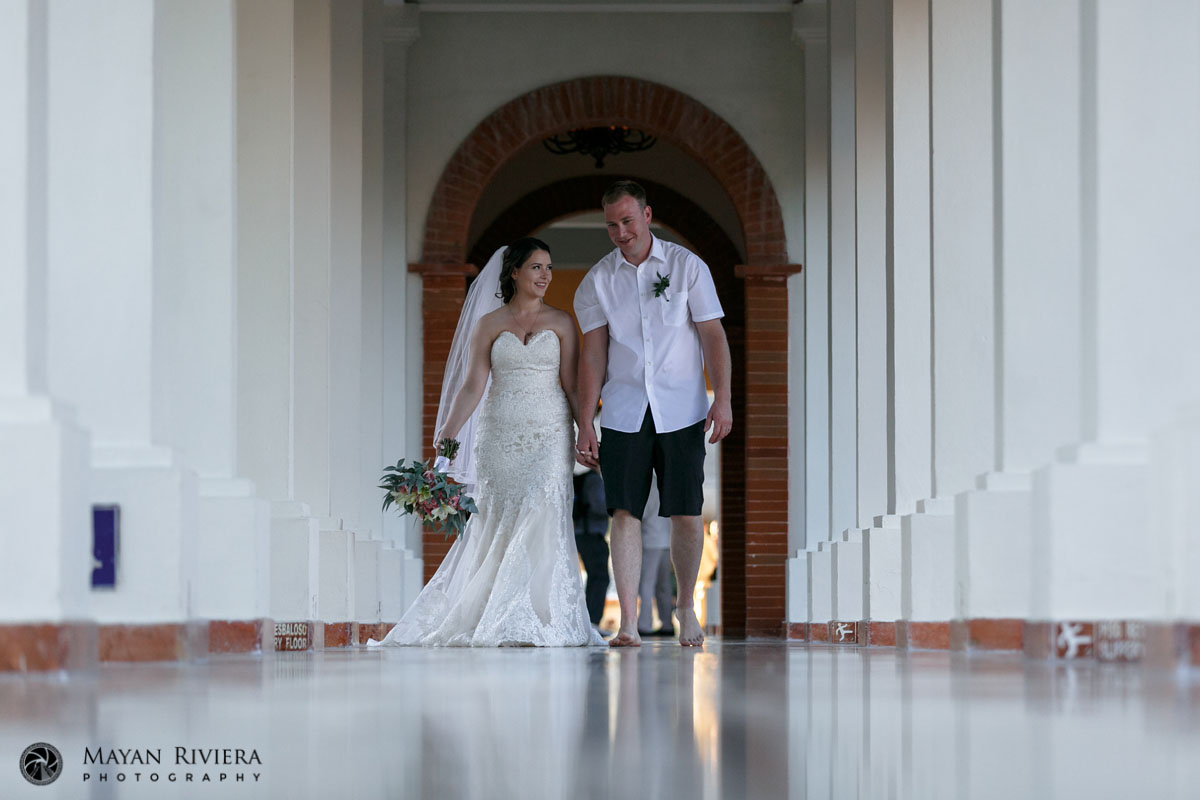 NewlywedsWalkingColumedHallway