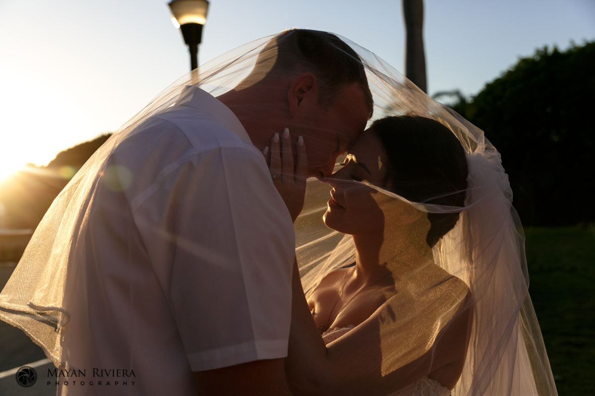 NewlywedsPoseUnderSunlitVeil