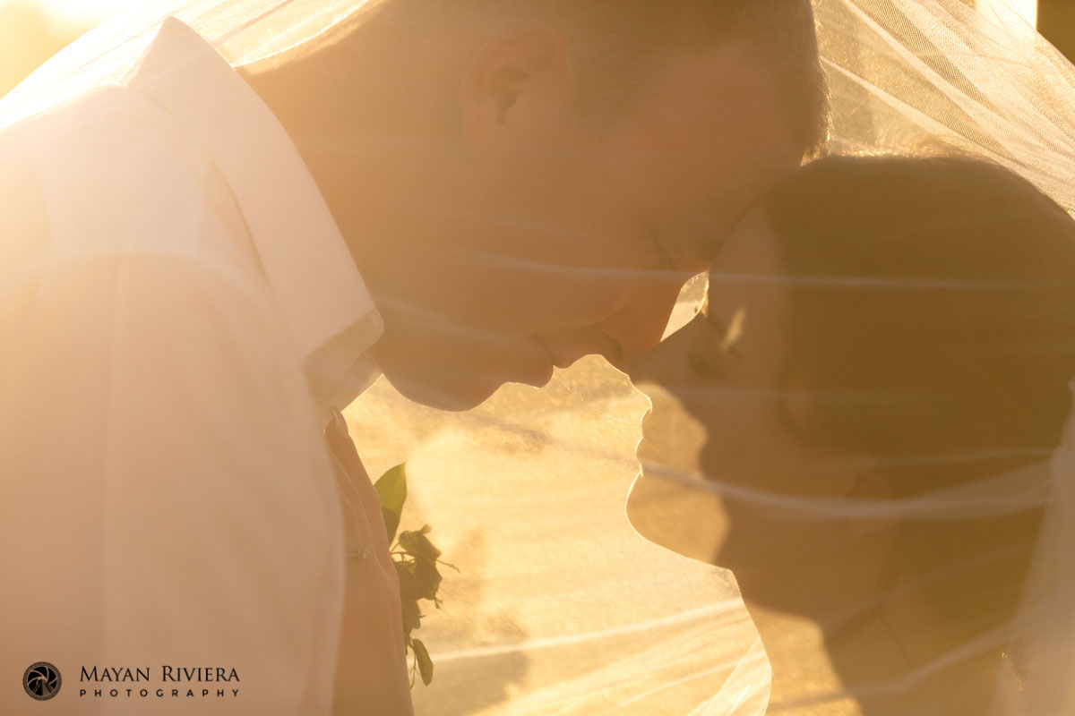 NewlywedsPoseUnderSunlitVeil