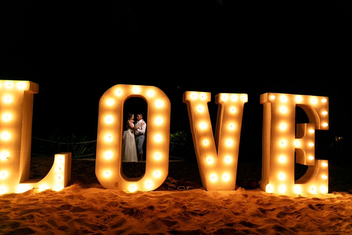 NewlywedsDanceBehindLoveSign
