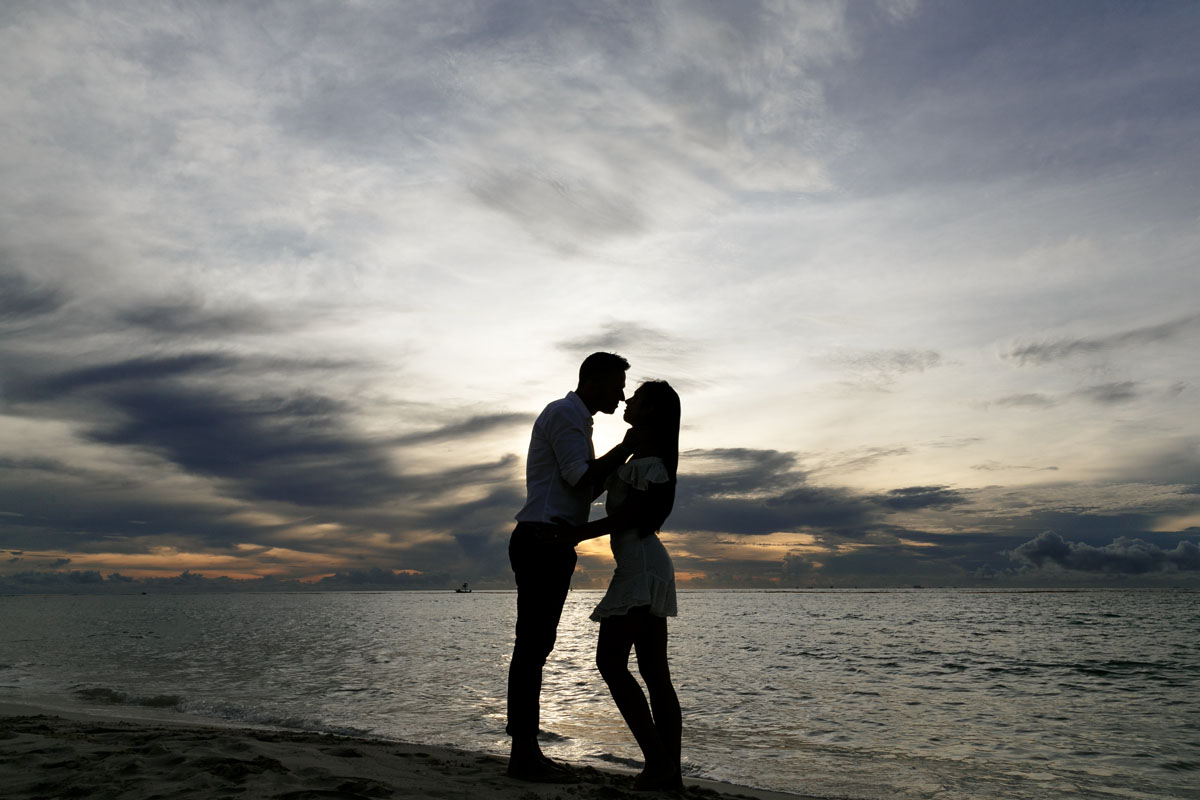 NewlyEngagedCouplePoseOnPdCBeachAtSunrise