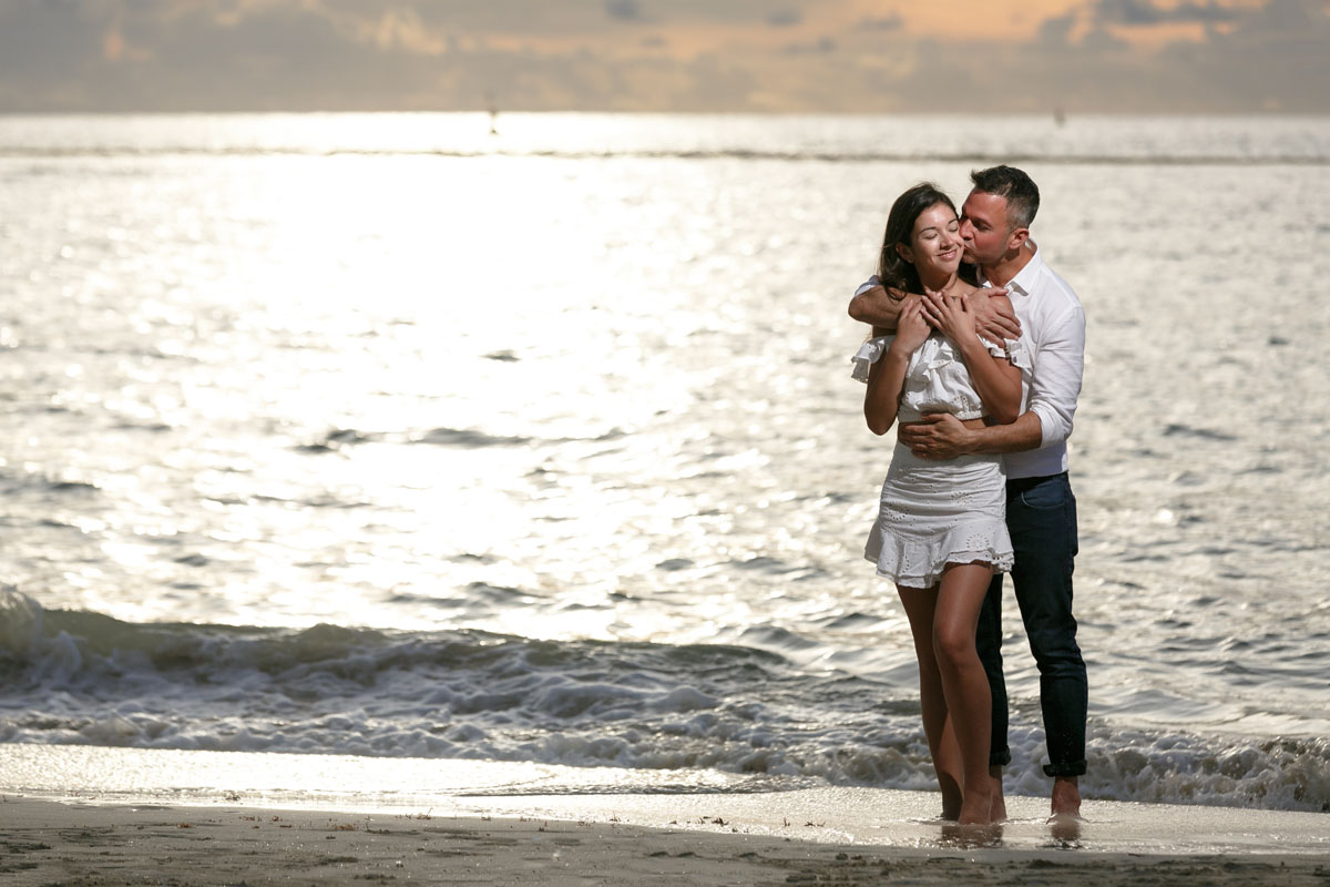NewlyEngagedCoupleKissOnPdCBeachAtSunrise